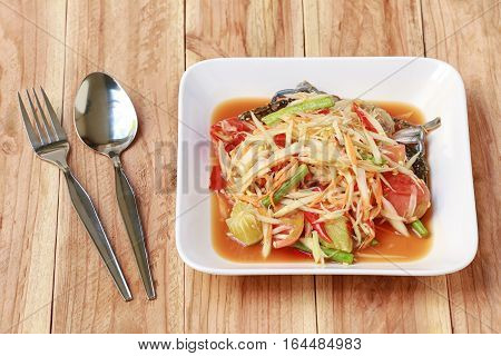 SOM TUMThai foods or papaya salad in spicy taste and is popular in thailand on wooden table background.