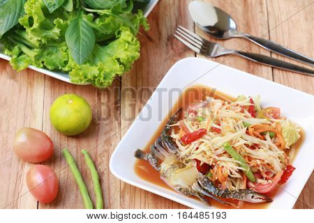 SOM TUMThai foods or papaya salad in spicy taste and is popular in thailand on wooden table background.