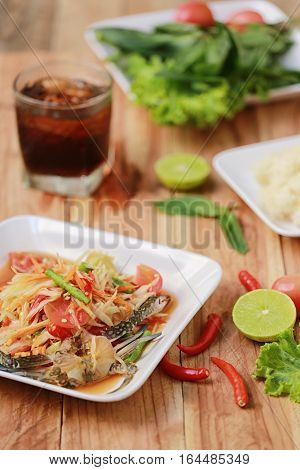 SOM TUMThai foods or papaya salad in spicy taste and is popular in thailand on wooden table background.