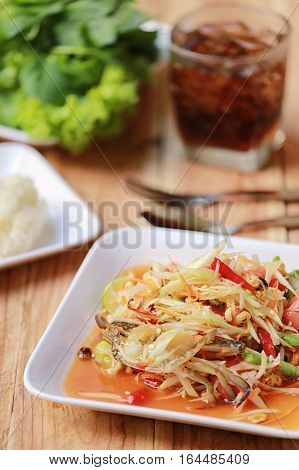 SOM TUMThai foods or papaya salad in spicy taste and is popular in thailand on wooden table background.