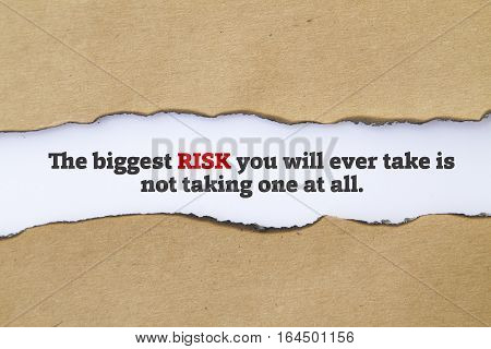 The biggest risk you will ever take is not taking one at all message written under torn paper.