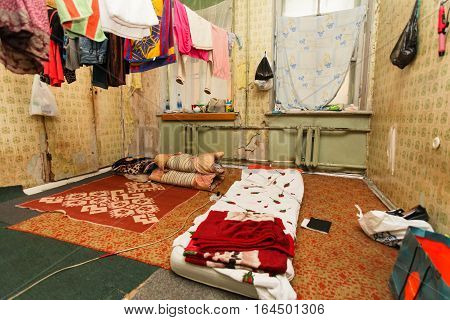 Sleeping area for refugee and refugees' clothes is drying of on the rope in the temporary apartment