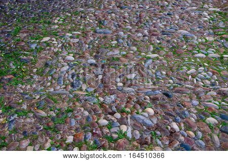 colored brown, blue, light, dark sea pebbles laid out on the track