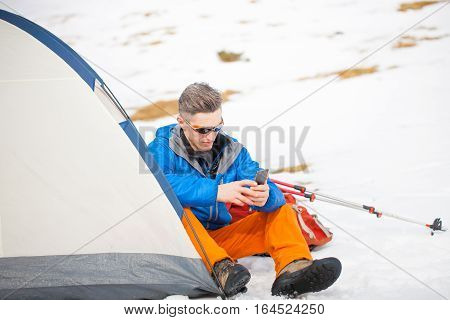 A Man Sits In A Tent In The Winter.