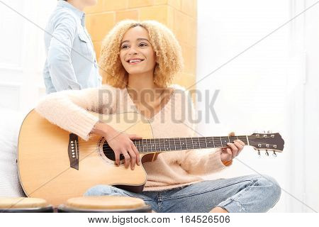 Acoustic guitar. Relax while playing the guitar. Girl playing the guitar. The girl guitar tunes.