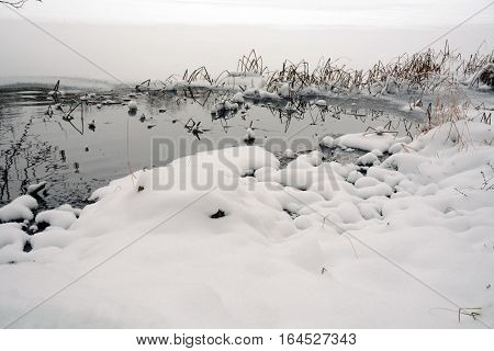 Thawed patch on the frozen lake in the winter