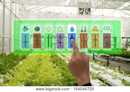 internet of things industrial agriculture and smart farming concept,farmer point hand to use augmeted reality application to control monitor and controlling condition of vegetable in the greenhouse