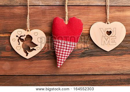 Fabric and wooden hearts. Cut-out Cupid on wooden background. Celebration of love.
