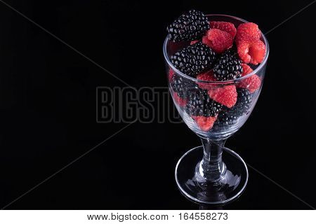 Blackberries and raspberries in a stemmed glass