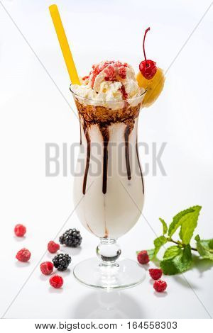 Milkshakes with black currant, cherry, raspberry in glass on the background of wooden boards