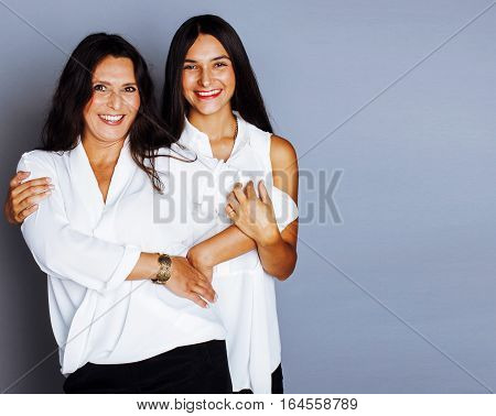 cute pretty teen daughter with mature mother hugging, fashion style brunette, lifestyle people concept close up