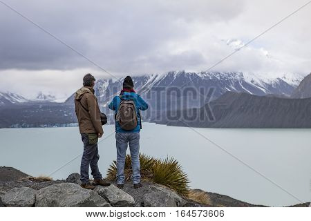 MT.COOK NATIONAL PARK NEW ZEALAND - august 31: two of tourist man standing and looking to mt.johnson foggy day in aoraki-mt.cook national park new zealand on august31 2015