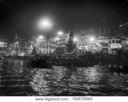 VARANASI, INDIA - NOVEMBER 15, 2016: A funerary ghat or crematorium on the banks of the Ganges River is fully illuminated at night during the festival of Dev Diwali