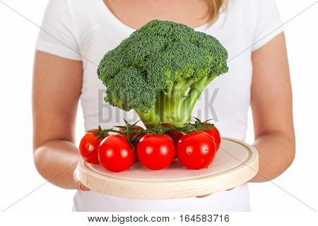Picture of fresh broccoli and cherry tomatoes held by a young woman