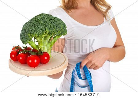Picture of fresh vegetables and measurer ina young woman's hands