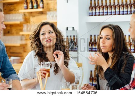 Two women and men smilingeating and drinking at table