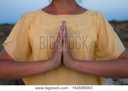 Hand Of A Woman Meditating In A Yoga Pose On The Beach At Sunset