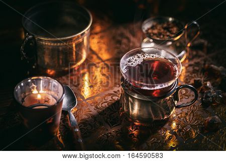Black tea in a glass cup at candle light