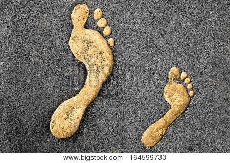 Golden right foot prints in a rocky surface
