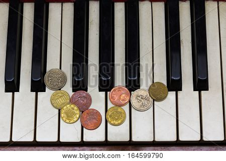 Old piano keys and coins, pay for music concept