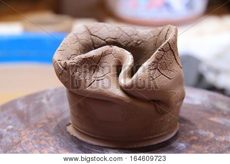 A clay pot on a pottery wheel, pottery craft, moulding the pot with your hands, sculpting hands