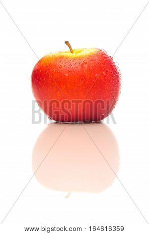 Closeup studio shot on white background of a red apple sprinkled with water