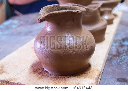 A clay pot, pottery craft, moulding the pot with your hands, sculpting hands