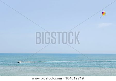 Colored Parasail Wing In The Blue Sky, Parasailing Also Known As Parascending Or Parakiting. Ship On