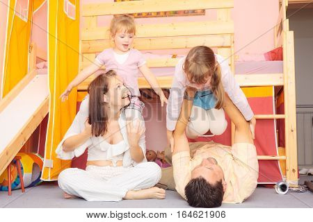a family are lying on the nursery's floor.