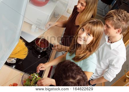 Group of friends cooking together at home.