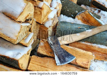 Stacked firewood in winter under the snow. Stock photo