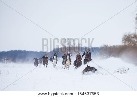 Pietrosani Romania - January 6 2017: People race their horses on a snowy field during a traditional Epiphany horse race in Pietrosani Romania.