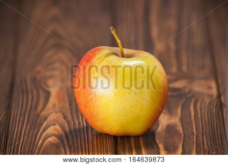 red and yellow apples on a wooden table