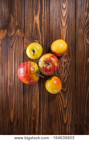 red and yellow apples on a wooden table