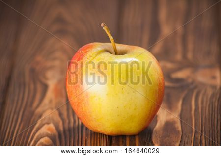 red and yellow apples on a wooden table