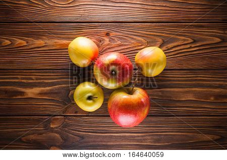 red and yellow apples on a wooden table