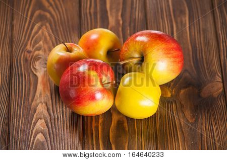red and yellow apples on a wooden table