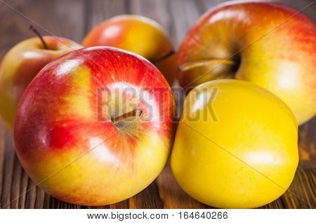 red and yellow apples on a wooden table