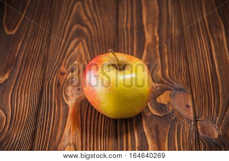 red and yellow apples on a wooden table