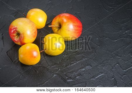 red and yellow apples on a black table