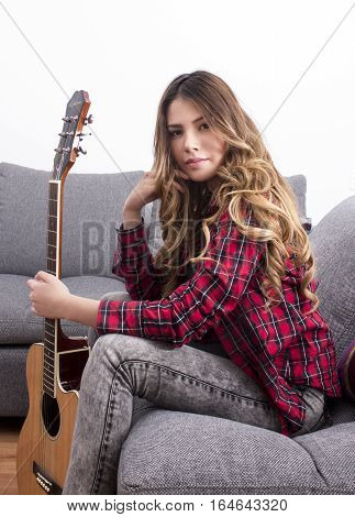 Portrait of a serious girl holding a guitar