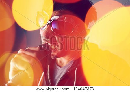Alternative rock music singer singing song into microphone bokeh light effect and selective focus