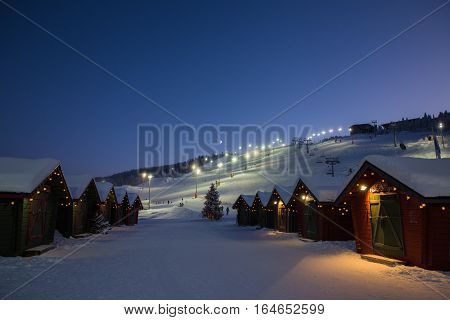 winter market village in Levi, Finland in the evenig on lightened ski cable way background