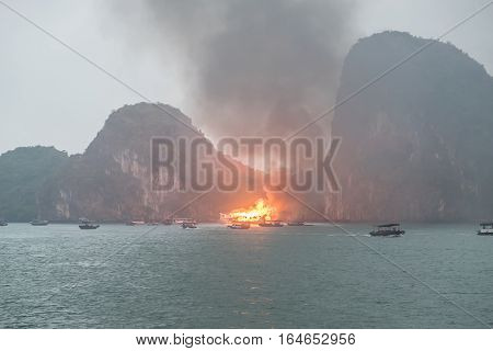 HALONGBAY VIETNAM - JAN 10 2017 : Burning boat with rescue boats.