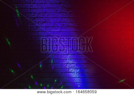 Textured brick wall lit by many colored lights