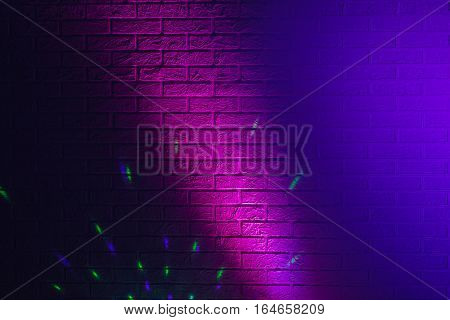 Textured brick wall lit by many colored lights