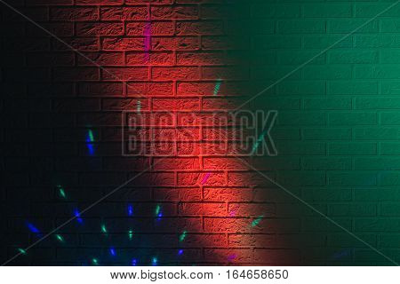Textured brick wall lit by many colored lights