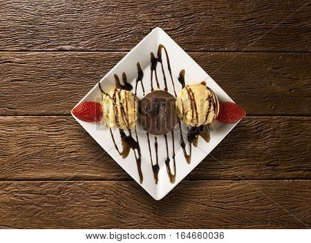Petit Gateau Dessert With Ice Cream And Strawberry On Wooden Background