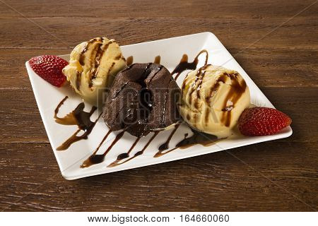 Petit Gateau Dessert With Ice Cream And Strawberry On Wooden Background
