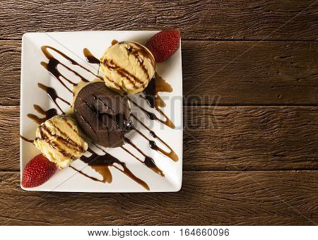 Petit Gateau Dessert With Ice Cream And Strawberry On Wooden Background